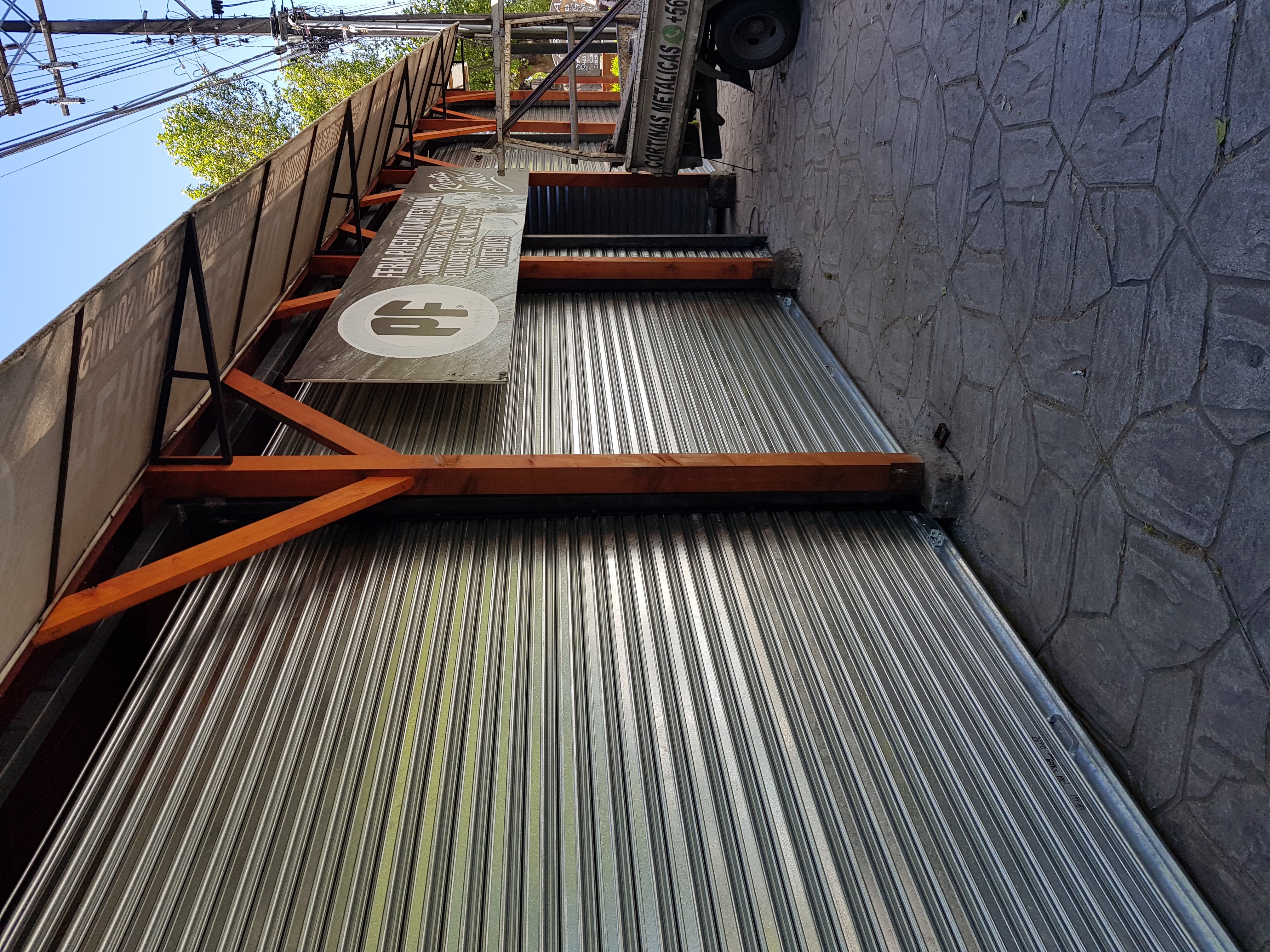 Instalación de cortinas metálicas emballetadas con grúa en estructura comercial